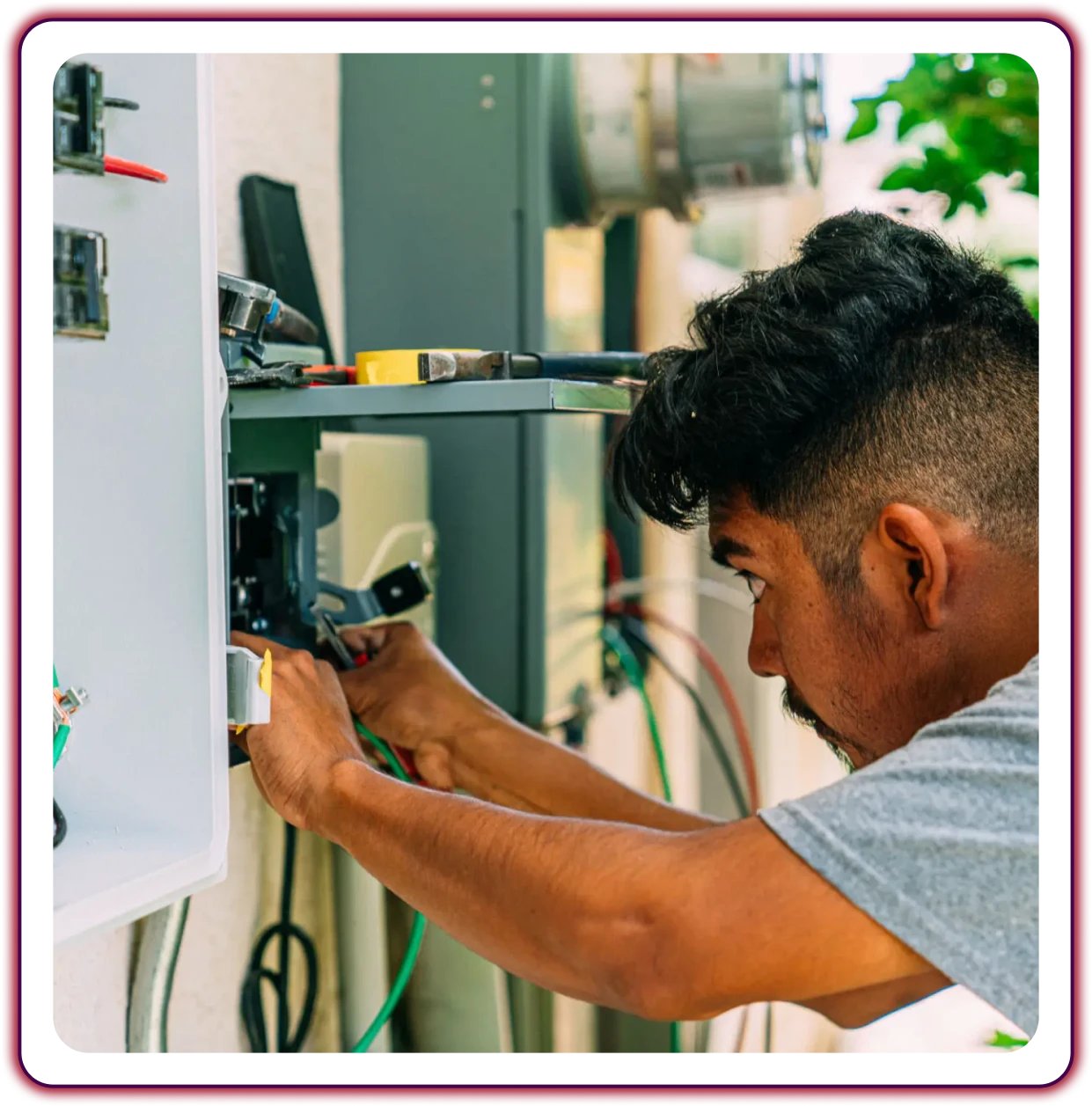 Man working on electrical panel outdoors.