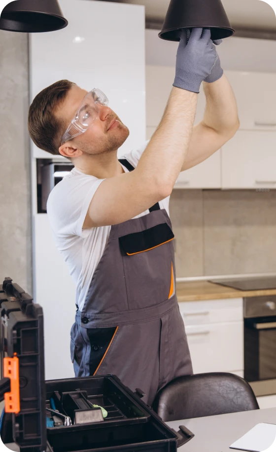 Man fixing light fixture in kitchen.