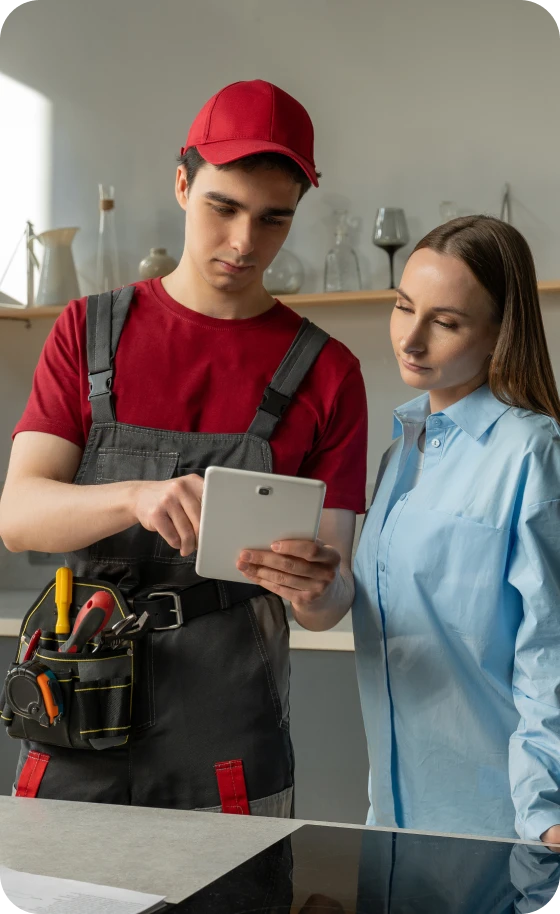 Worker showing woman a tablet screen.