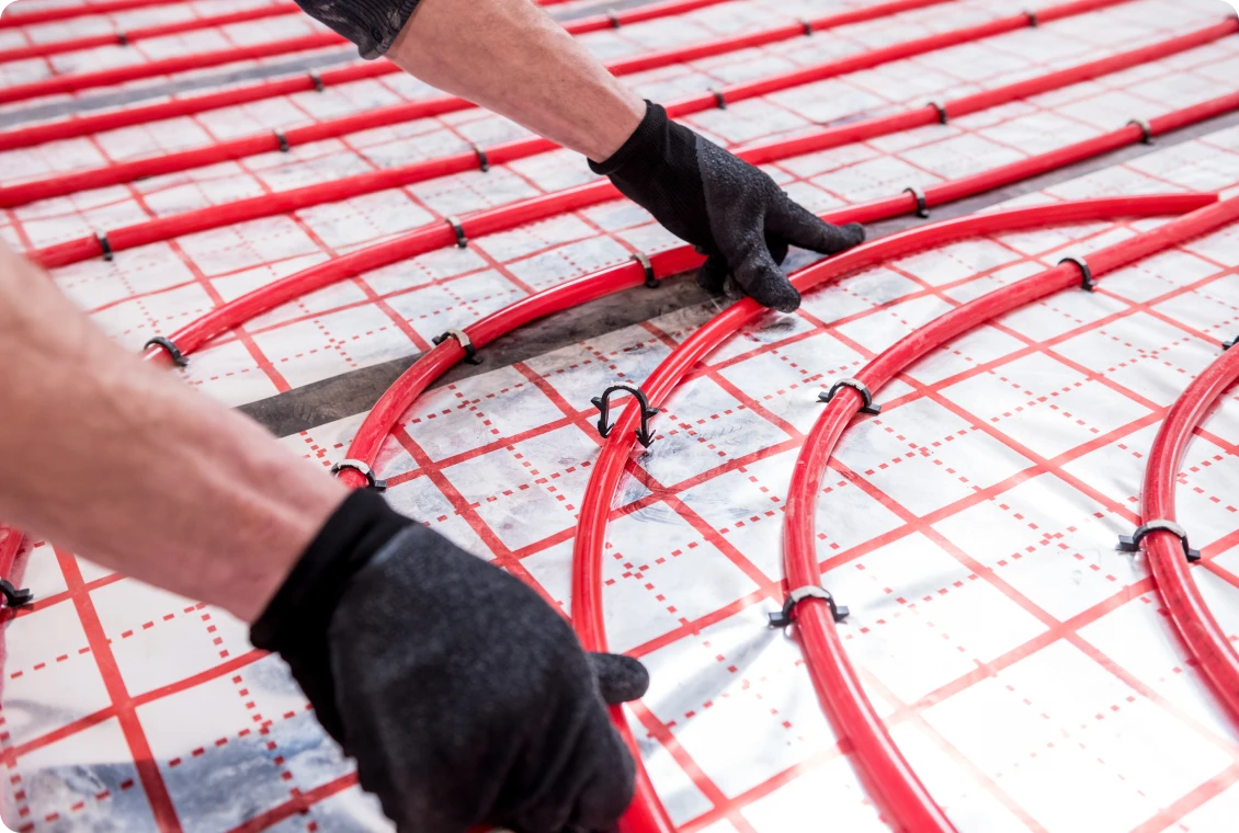Installing underfloor heating pipes with gloves.