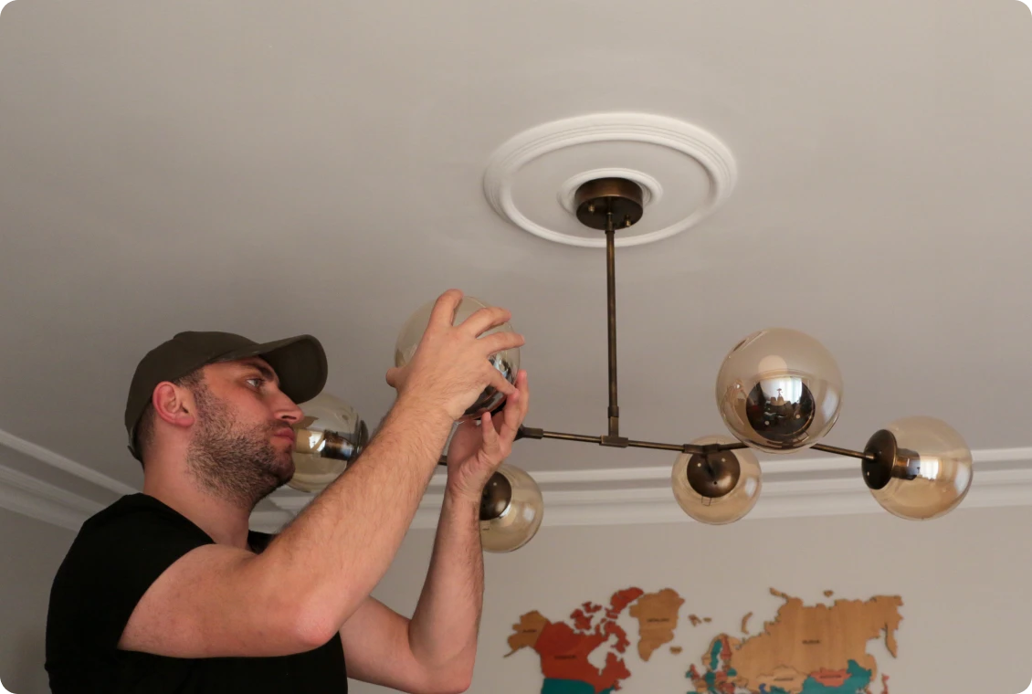 Man fixing a modern ceiling light fixture.