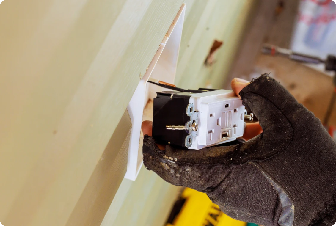 Installing an electrical outlet in wall.
