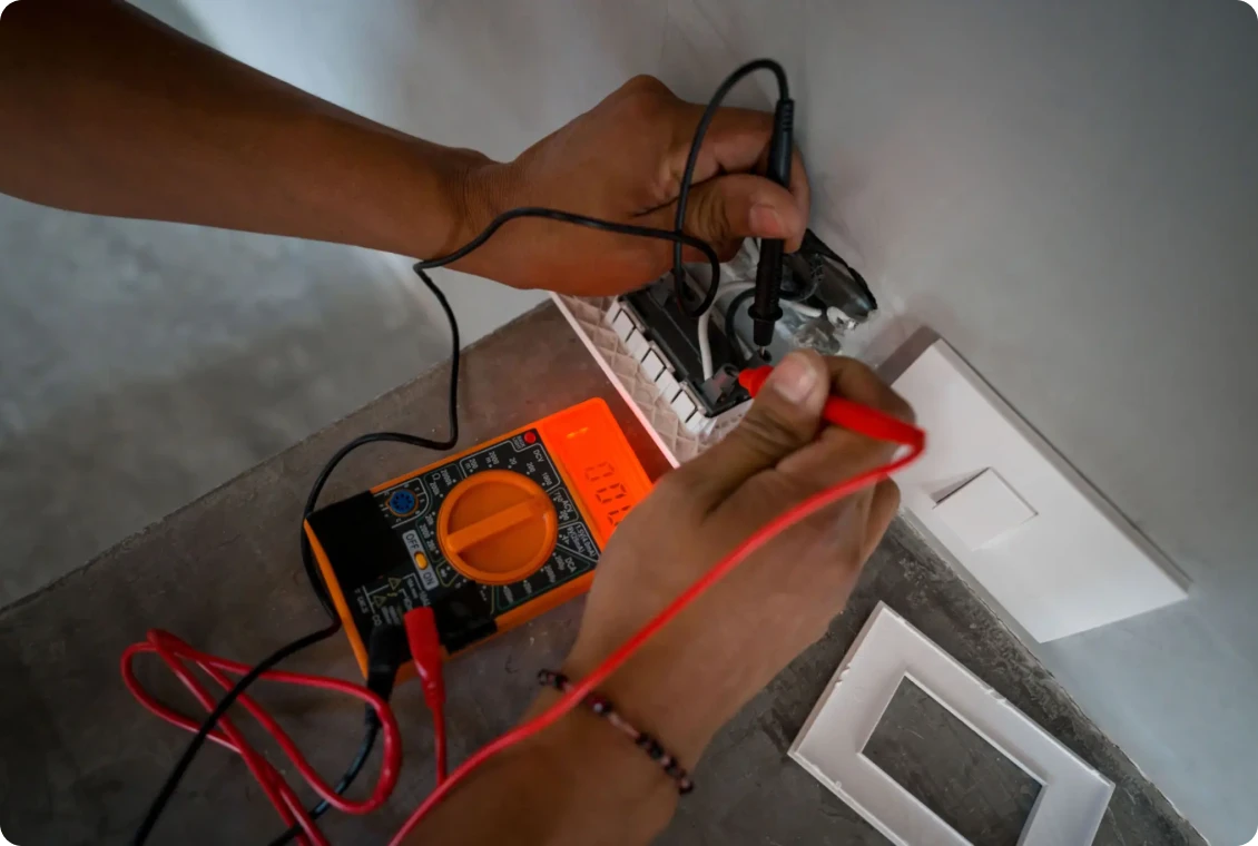 Testing electrical socket with a multimeter tool.