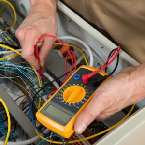 Person using multimeter on electrical wires.